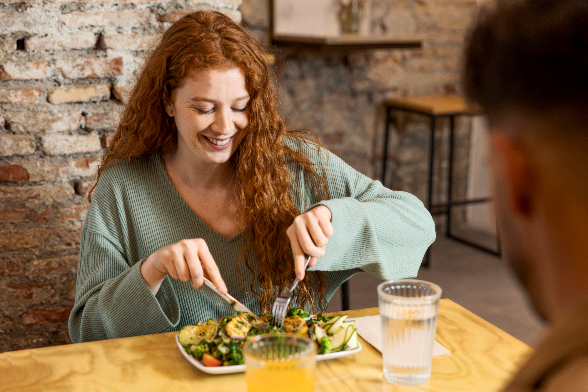 Mulher jovem de cabelos ruivos se alimenta de forma saudável para reduzir risco de infarto.