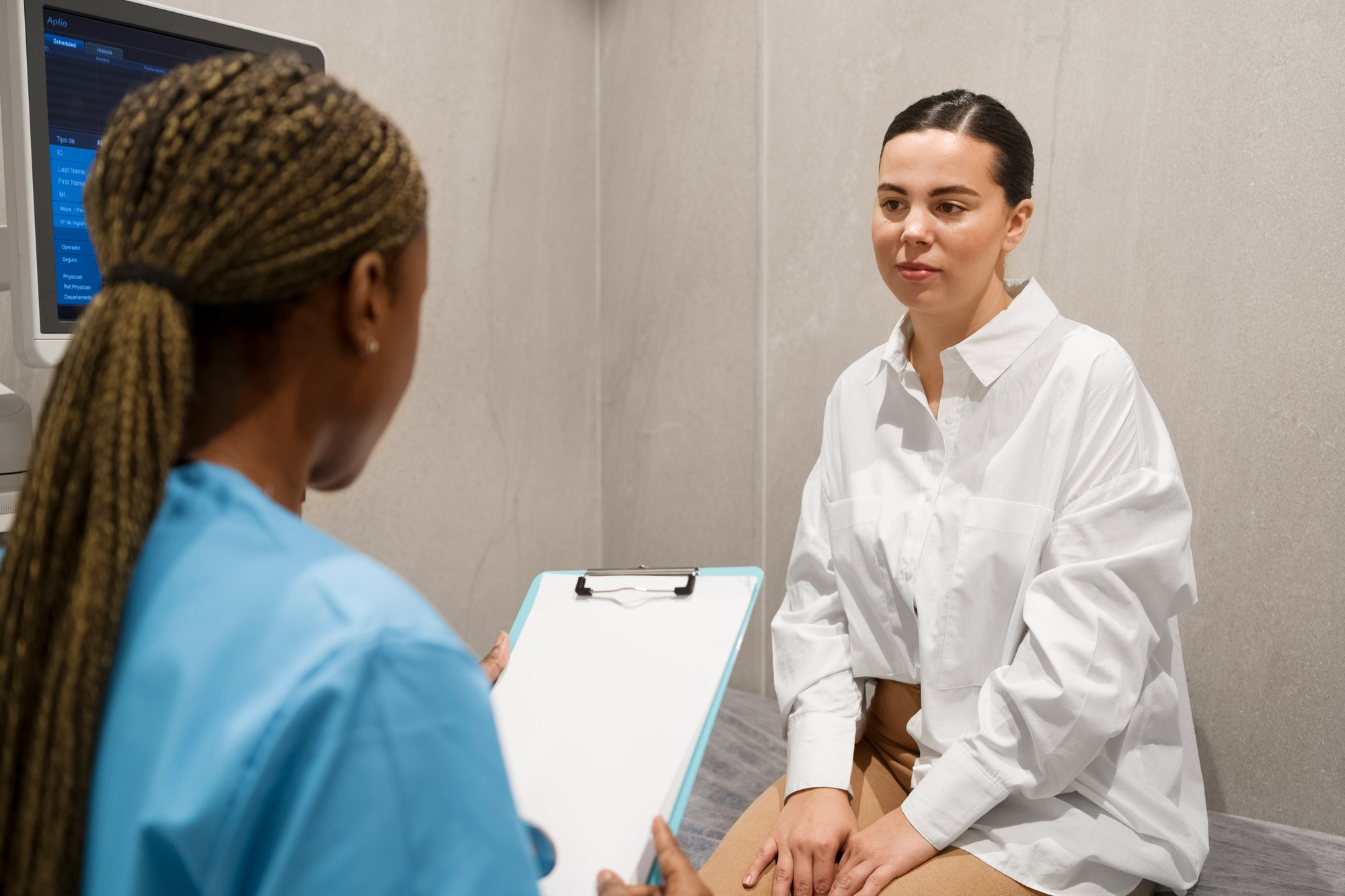 Mulher em consulta médica conversando com profissional de saúde, avaliando opções de contracepção como o DIU de cobre
