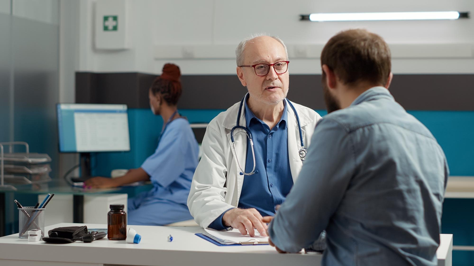 Médico conversando com paciente em consultório sobre recidiva do câncer, explicando possibilidades de retorno da doença após o tratamento
