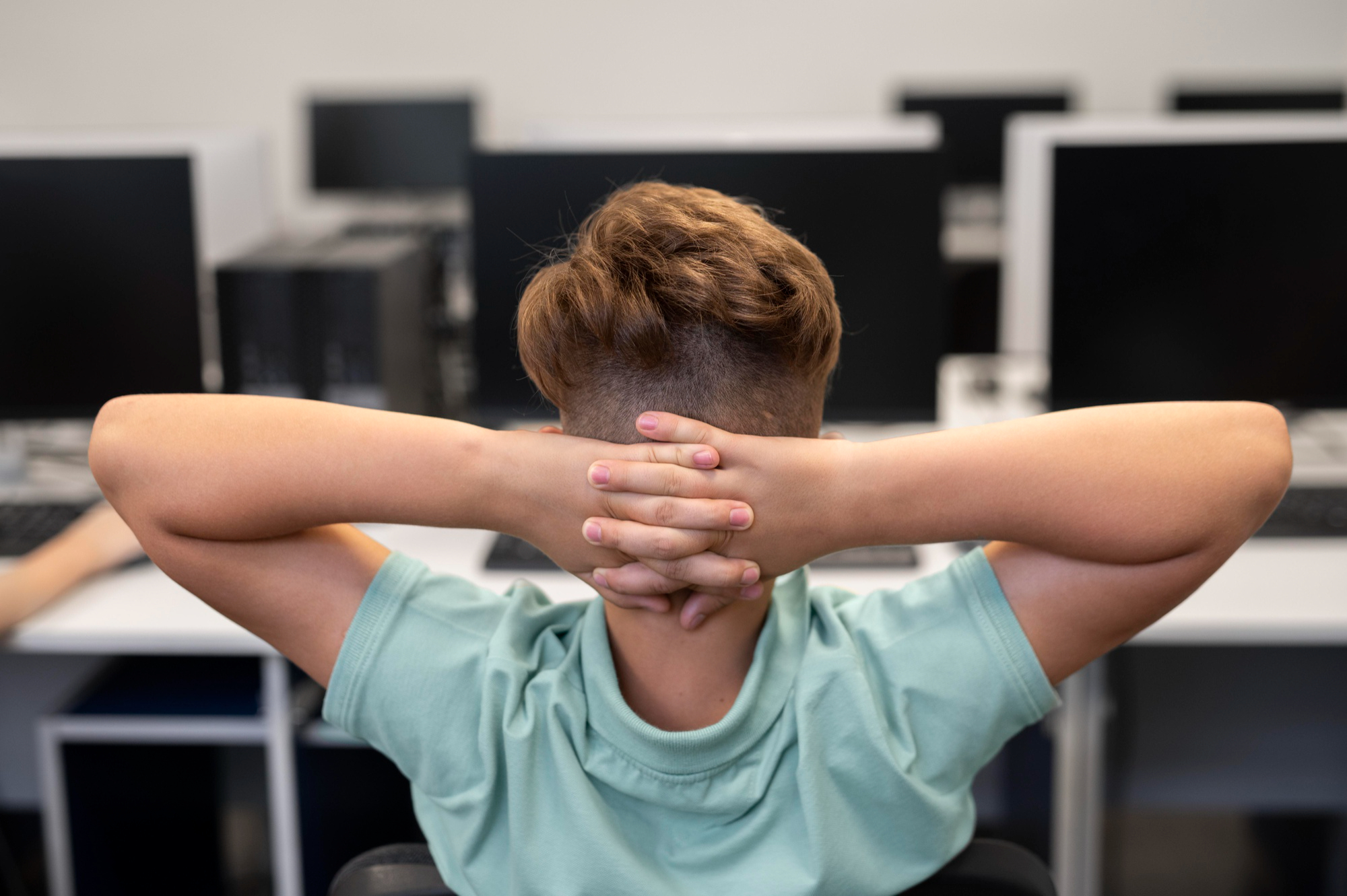 Adolescente com escoliose idiopática do adolescente alonga os braços em sala de aula
