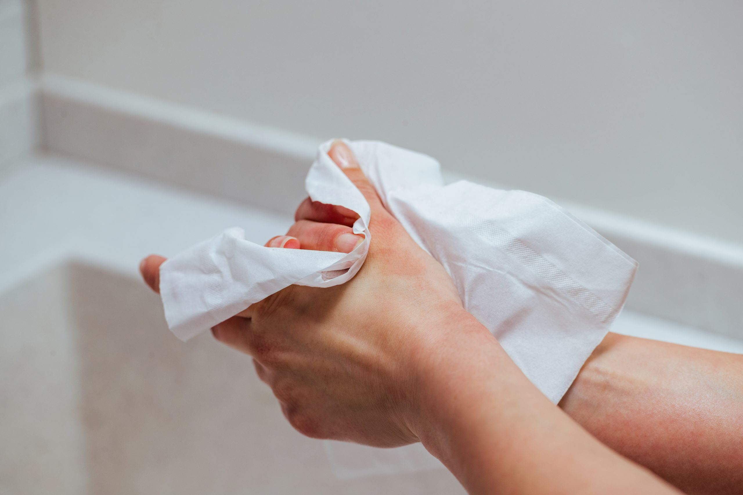 Pessoa enxuga as mãos com um lenço para aliviar o suor excessivo causado pela hiperidrose palmar.