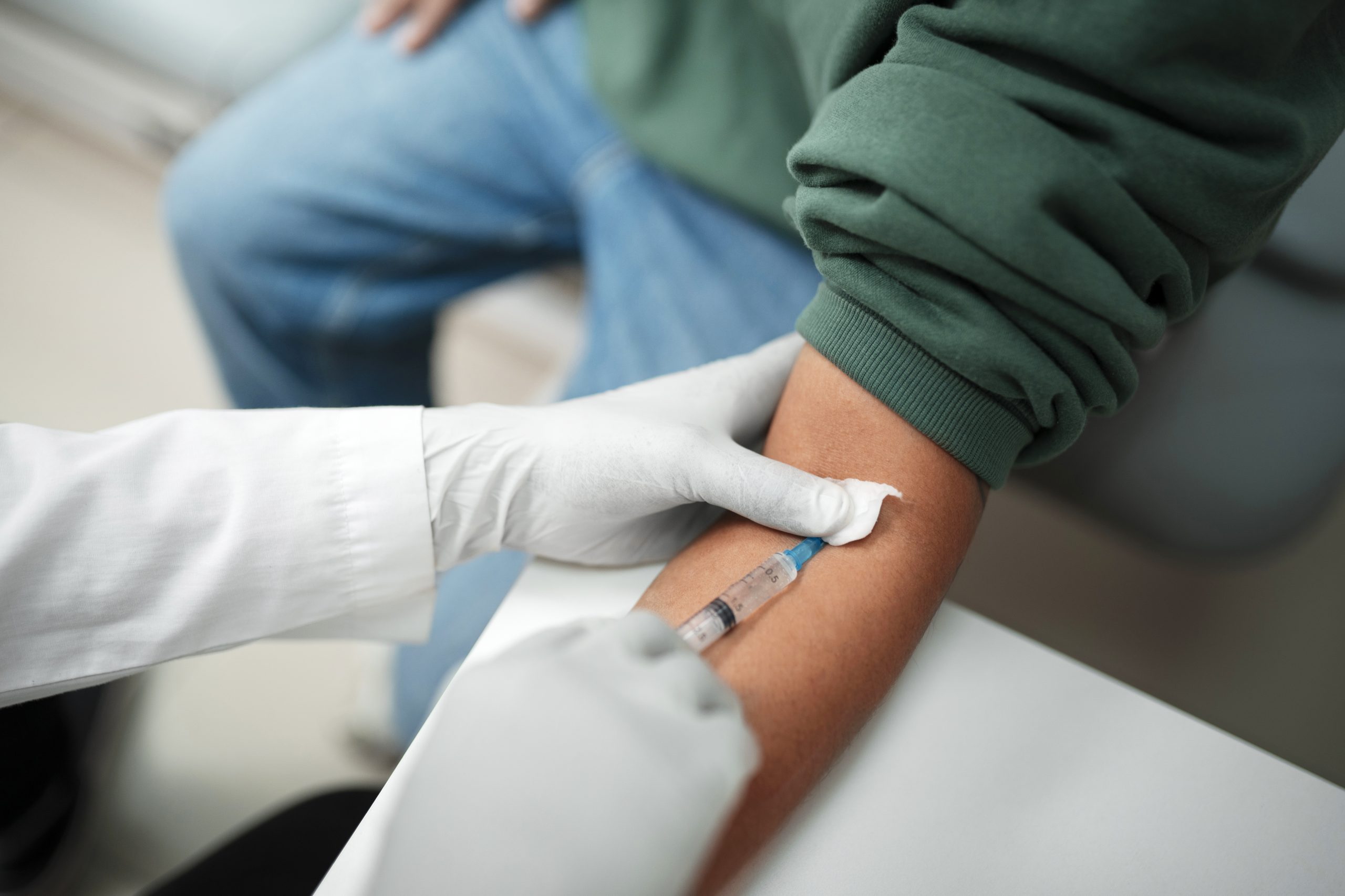 Profissional de saúde realiza coleta de sangue no braço de paciente para exame de PCR (Proteína C Reativa).
