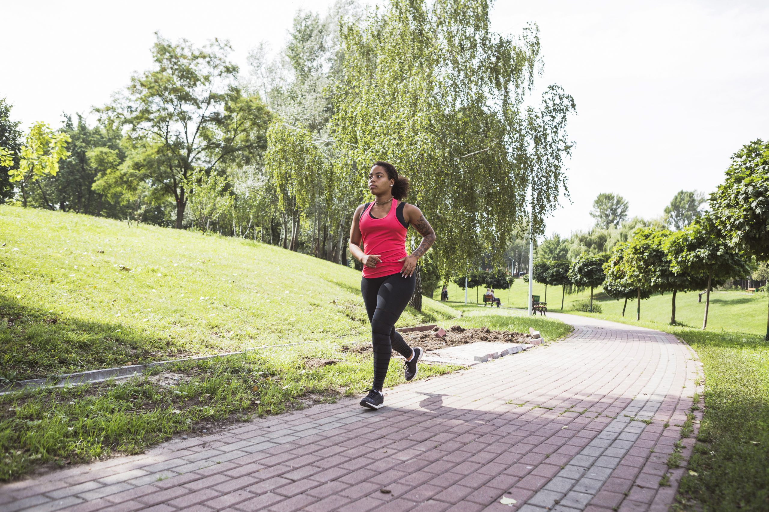 Mulher pratica caminhada ao ar livre em um parque, atividade física que pode ajudar a controlar o colesterol LDL e cuidar da saúde cardiovascular.