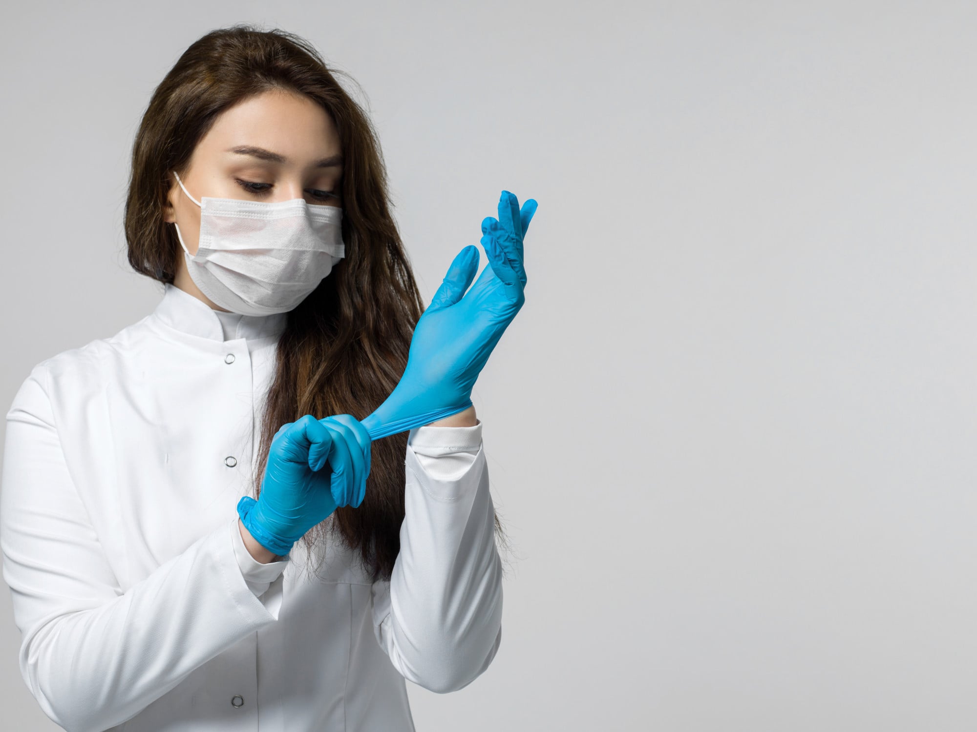 Luva de látex sendo utilizada por um profissional de saúde, destacando o risco de alergia em pessoas sensibilizadas.