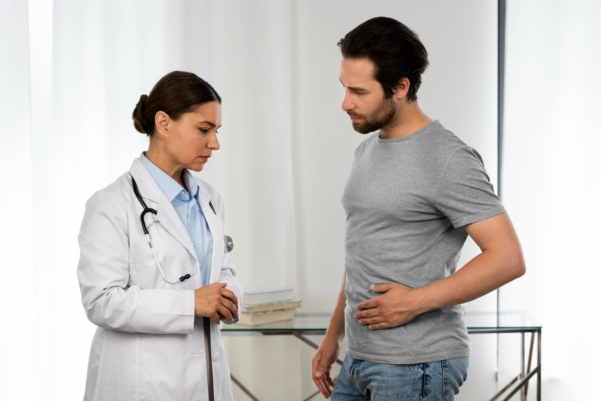 Médica examina paciente depois de exame de sangue ter apresentado TGO e TGP elevadas, representando alterações das enzimas hepáticas e investigação da saúde do fígado.