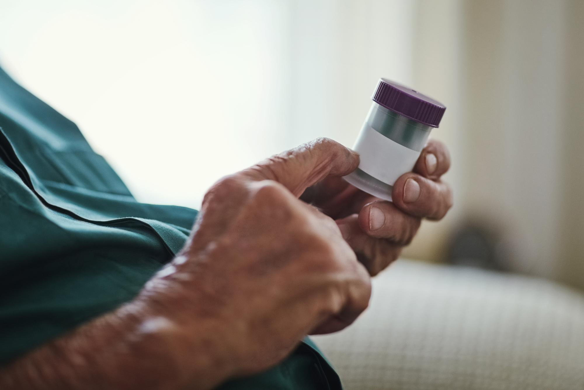 Pessoa segurando um exame laboratorial com resultado positivo para sangue oculto nas fezes.