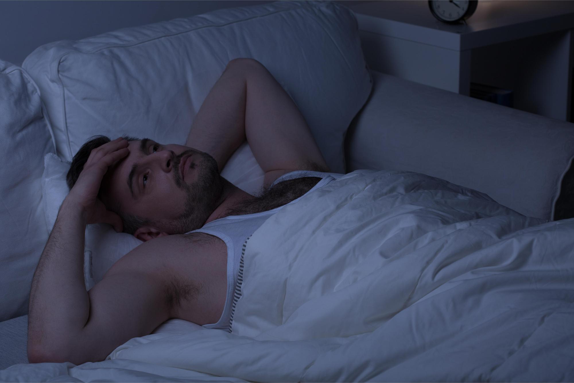 Pessoa acordando durante a noite com pijama encharcado devido à sudorese intensa.