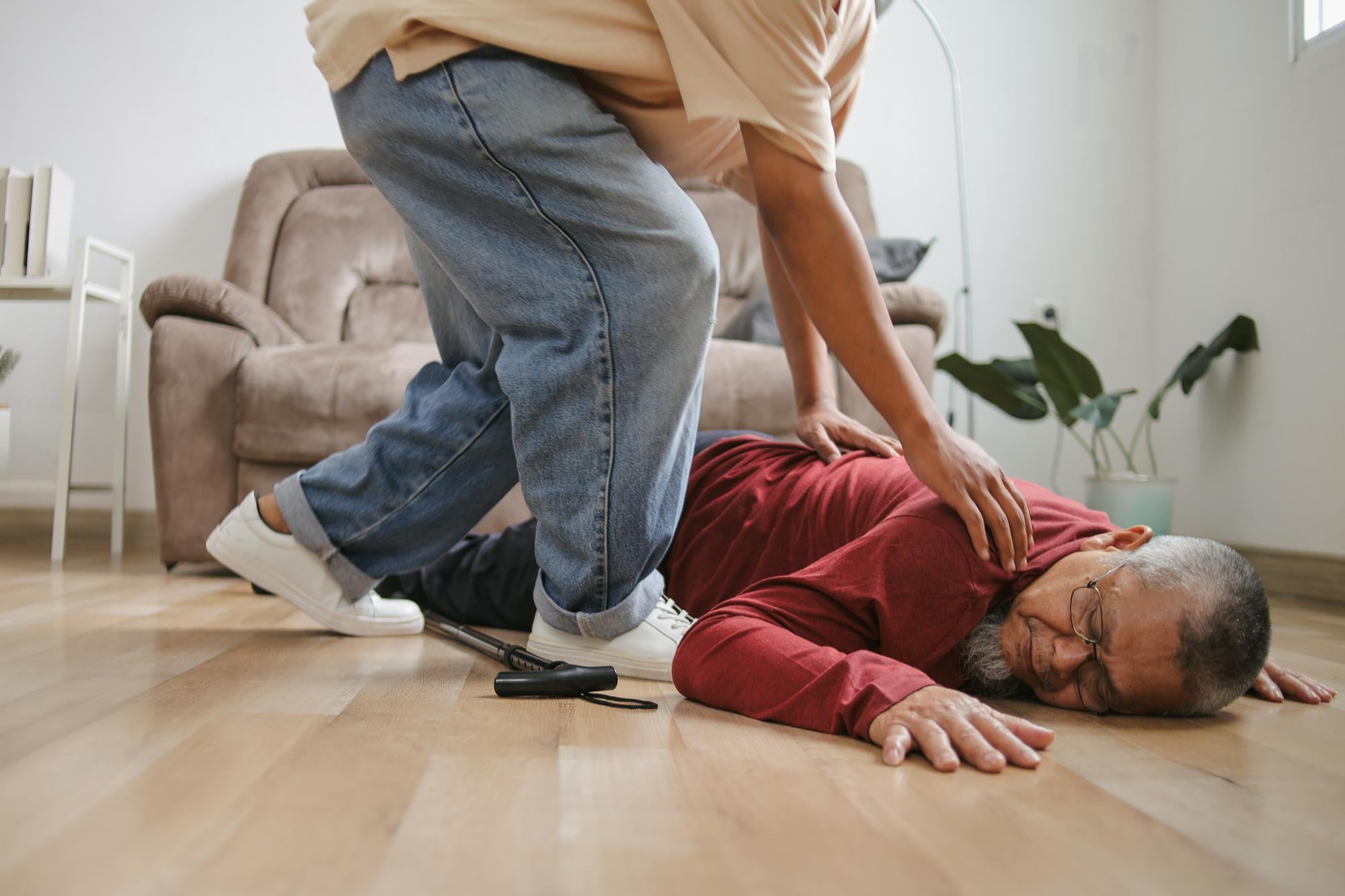 Pessoa recebendo primeiros socorros durante uma crise convulsiva, com proteção da cabeça e posicionamento lateral.