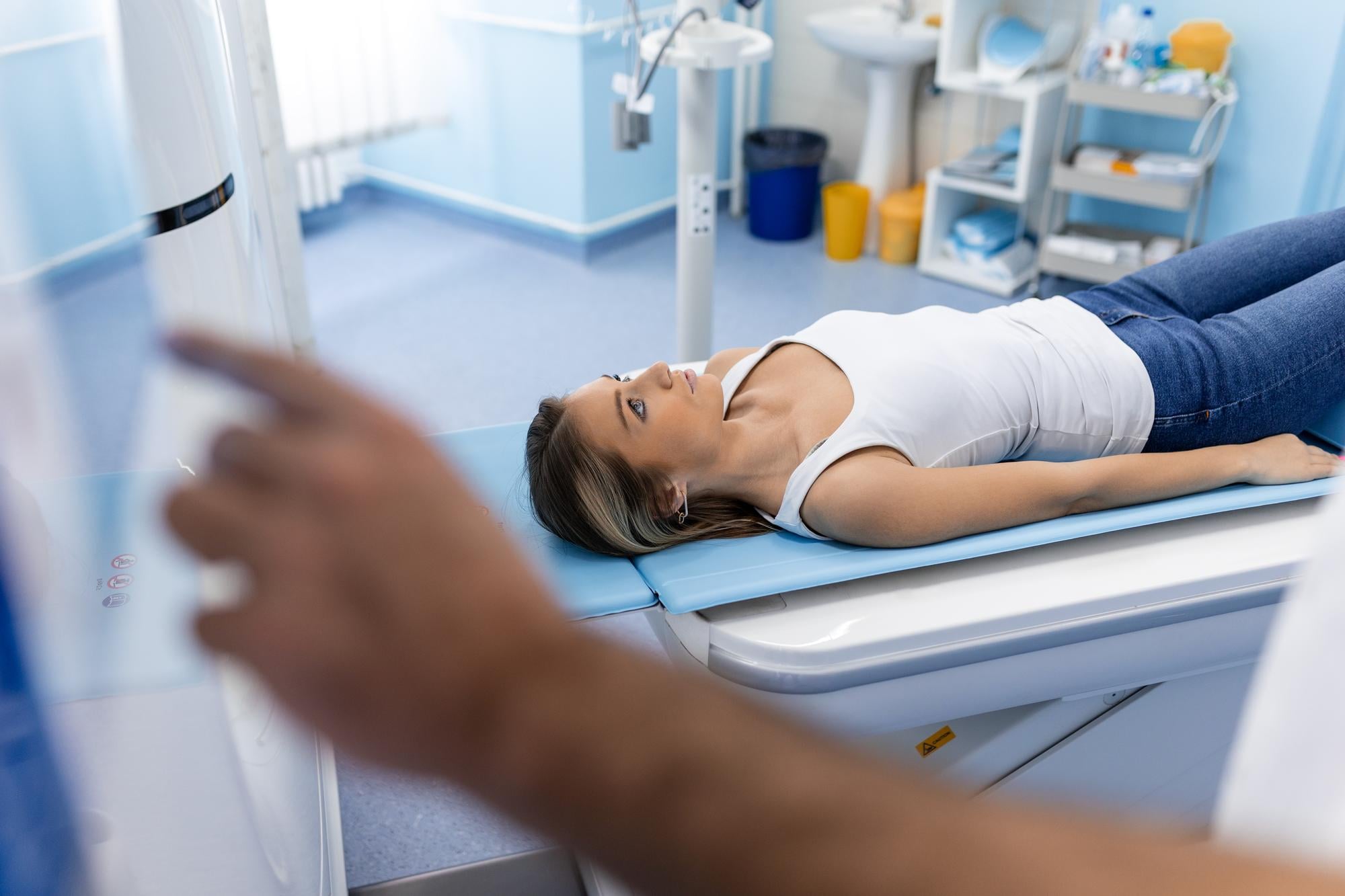 Mulher jovem realizando exame de densitometria óssea para avaliar a densidade mineral dos ossos.